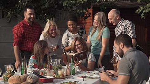 Family gathering around dinner table sharing a meal
